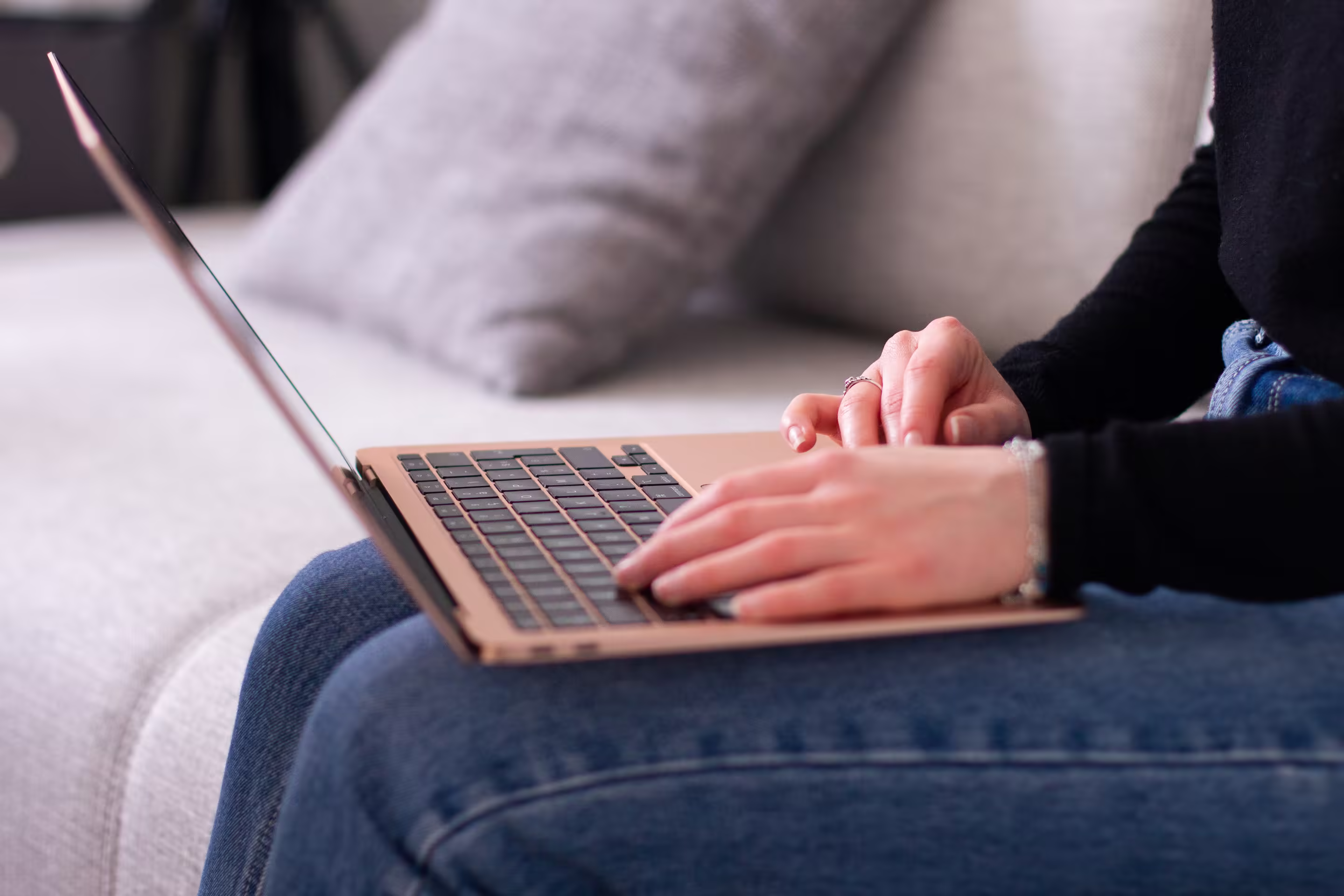 Personne assise avec un portable sur les genoux, en train de chercher